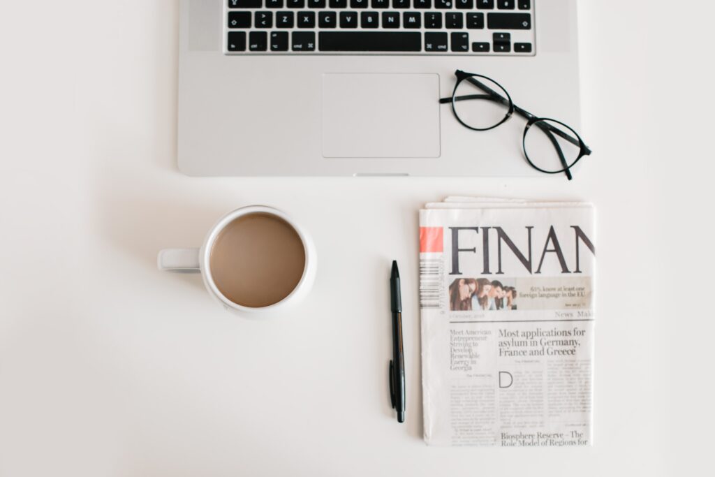 business-flat-lay-mac-coffee-glasses-and-newspaper