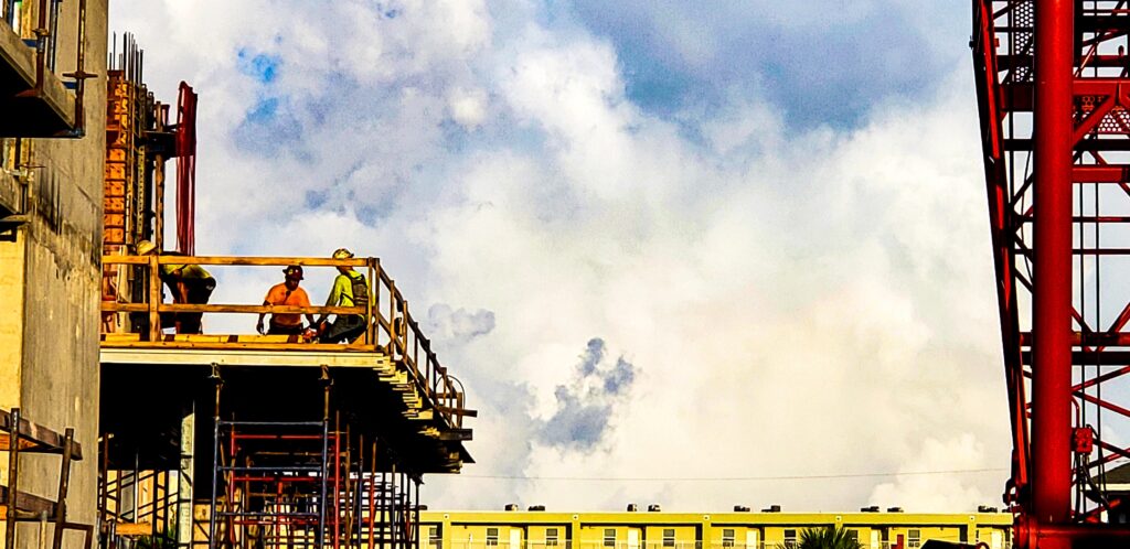 industrial-shot-with-crane-doing-the-heavy-lifting-while-the-construction-workers-do-the-smaller